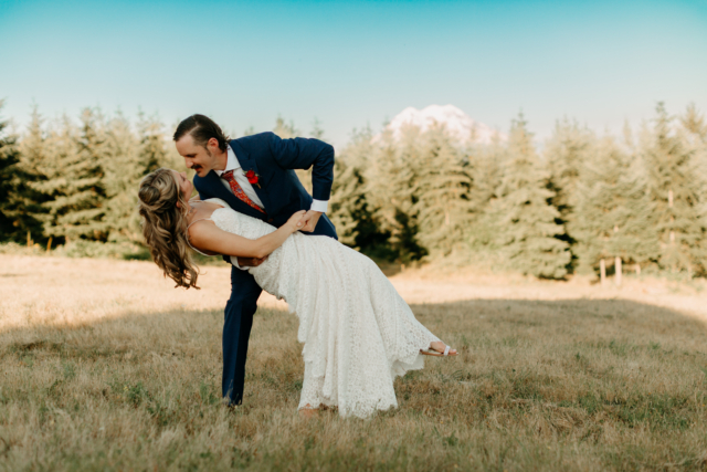 Groom Dips Bride in Field