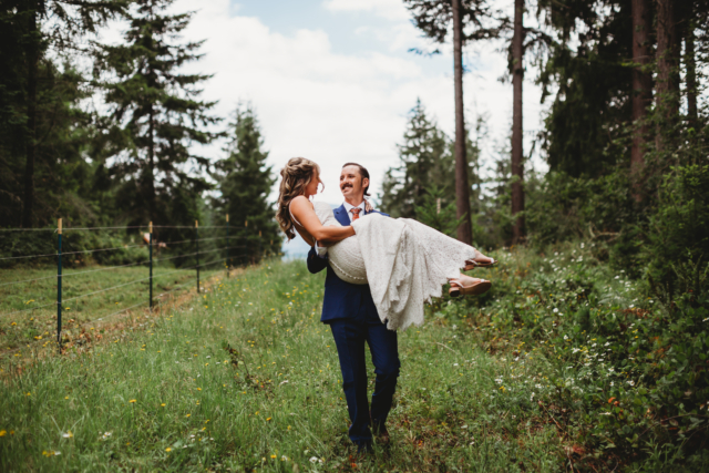 Groom Carrying Bride in Woods